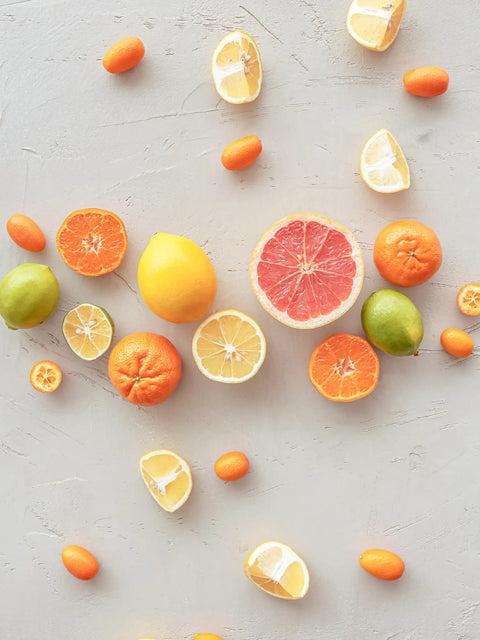 citron, lime, pelsin och kumquats mot vitt golv