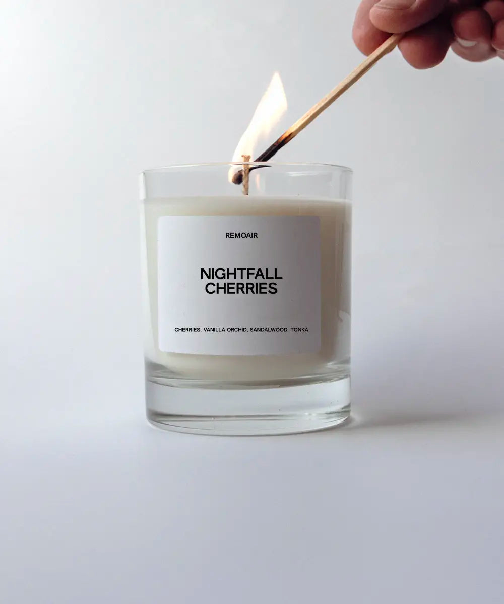 Nightfall Cherries doftljus i transparent glas där en tändsticka tänder veken ⎯ minimalistiskt foto.