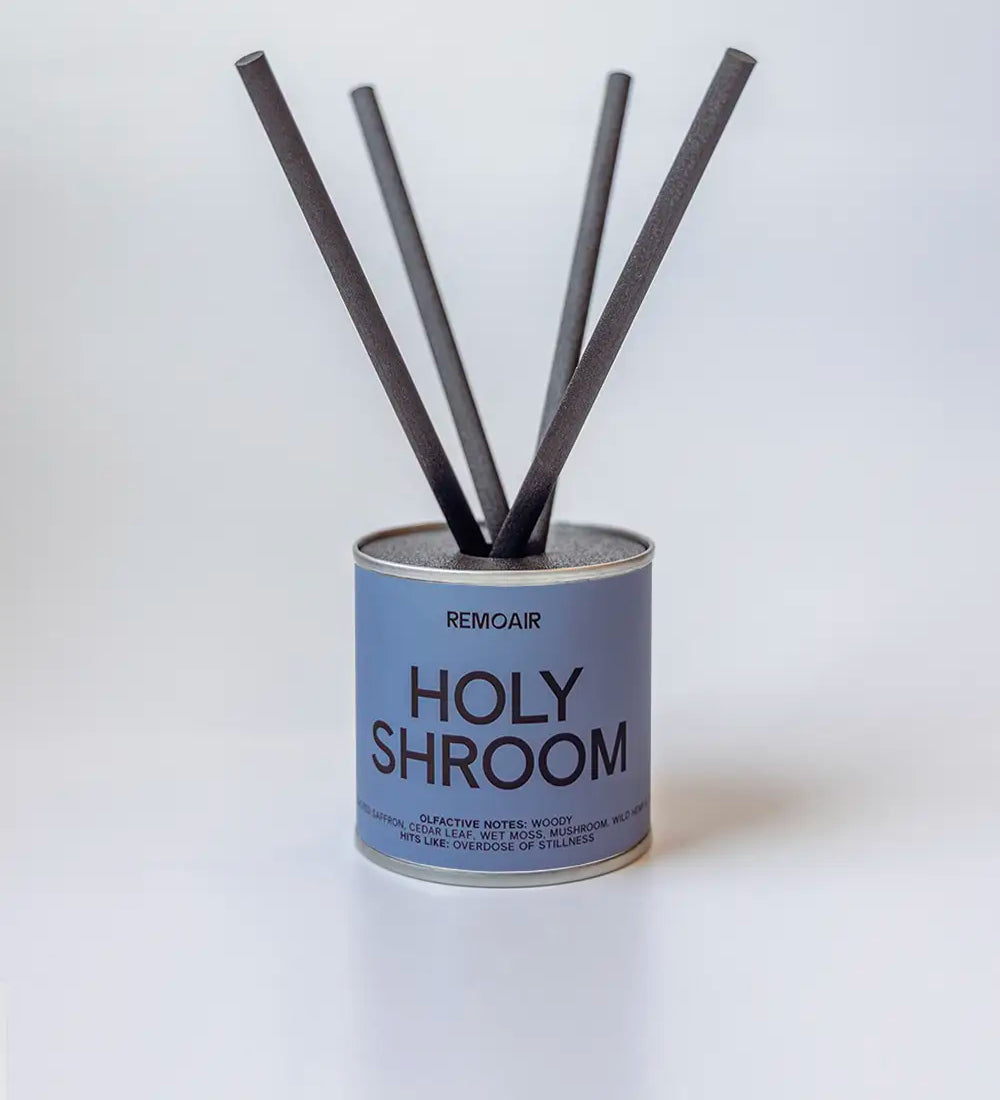 Holy Shroom doftpinnar i metallburk med svarta fiberstickor ⎯ clean och minimalistisk studiomiljö.