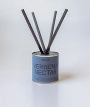Verbena Nectar doftpinnar i metallburk med svarta stickor ⎯ minimalistiskt och ljust produktfoto.