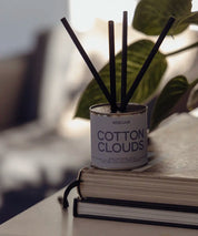 Minimalistisk doftspridare Cotton Clouds placerad på en trave böcker i ett modernt hem.