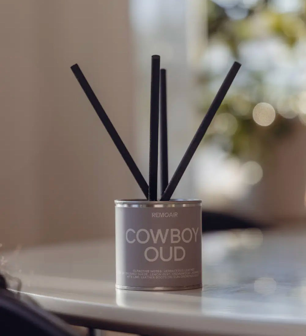 Närbild på Cowboy Oud doftpinnar med sober greige etikett och lyxiga korta stickor