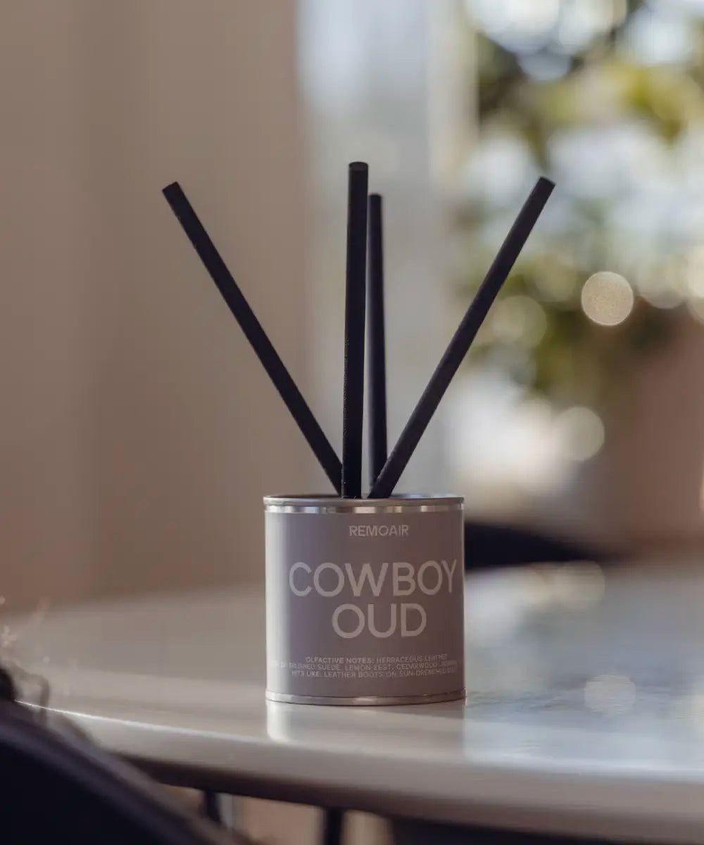 Närbild på Cowboy Oud doftpinnar med sober greige etikett och lyxiga korta stickor