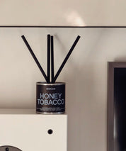 Stilren silverbehållare för veganska Honey Tobacco doftpinnar i en harmonisk inredningsmix.