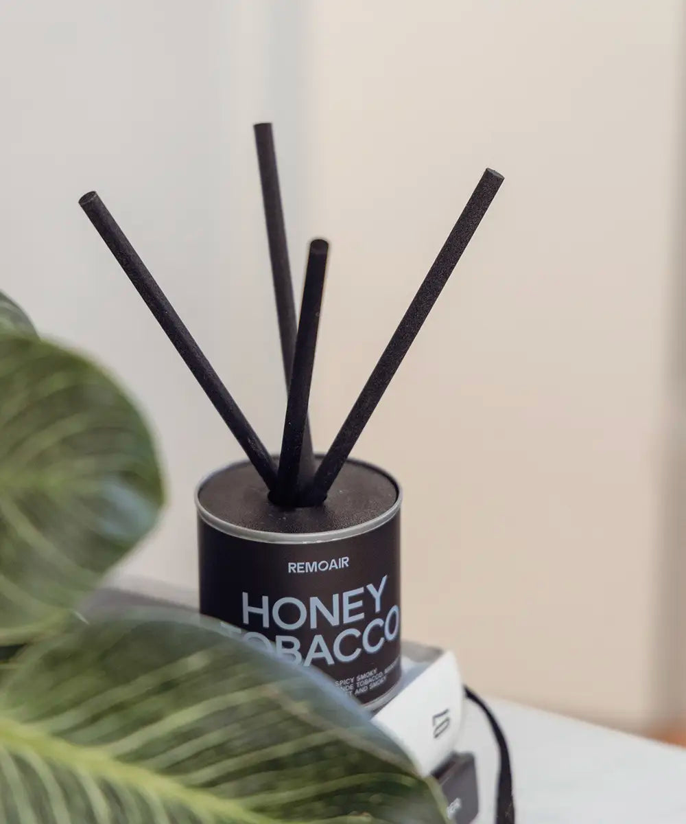 Närbild på Honey Tobacco doftset med ljusblå bokstäver och korta lyxiga svarta stickor.