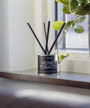 Lyxiga doftpinnar Honey Tobacco tillverkade i Sverige, placerade som en exklusiv inredningsdetalj.