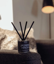 Jasmine Hinoki doftspridare med ljusblå text och korta svarta stickor i minimalistisk miljö