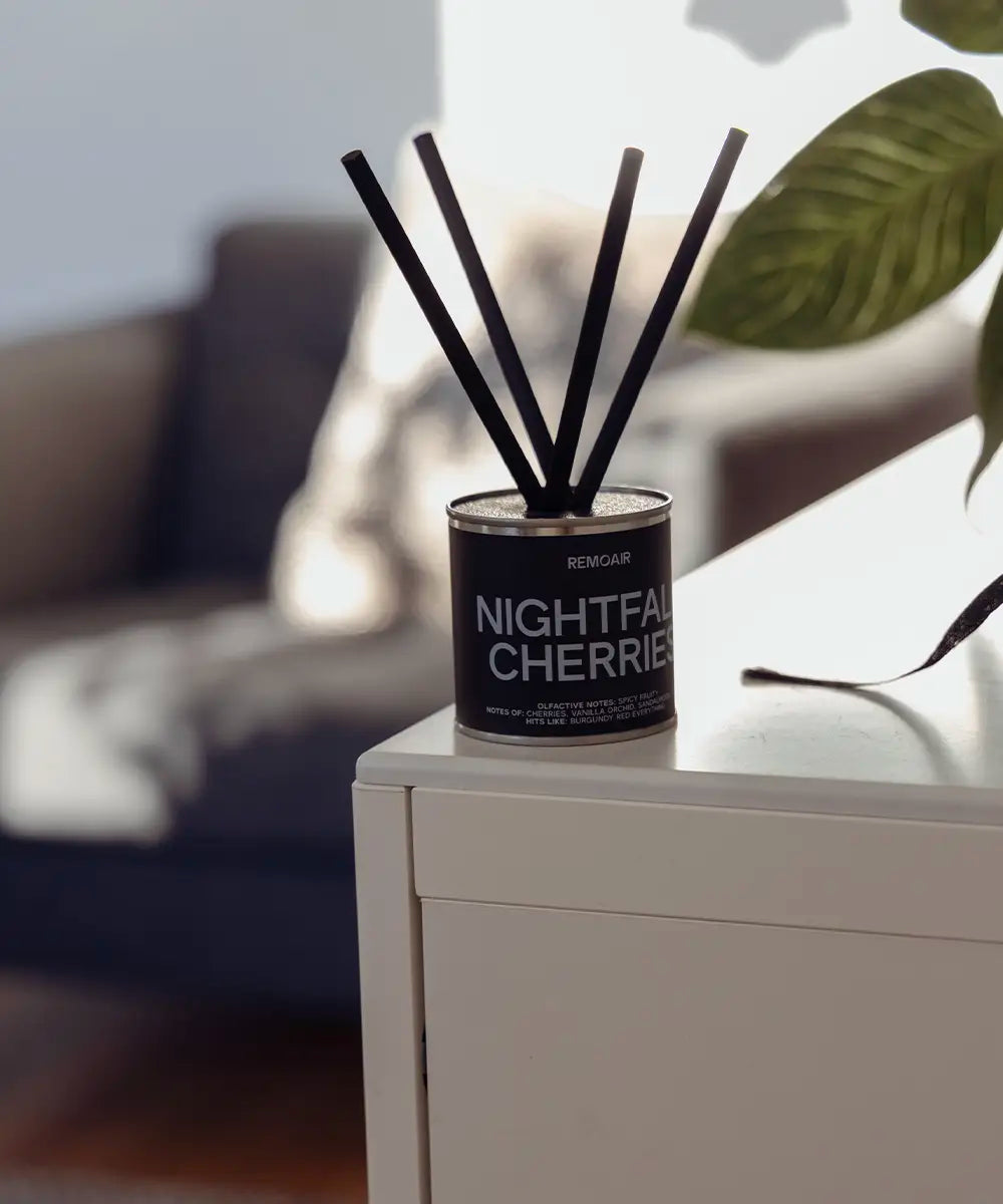 Stilren doftspridare Nightfall Cherries med dämpad mörkbrun etikett och ljusblå text som exklusiv inredningsdetalj.