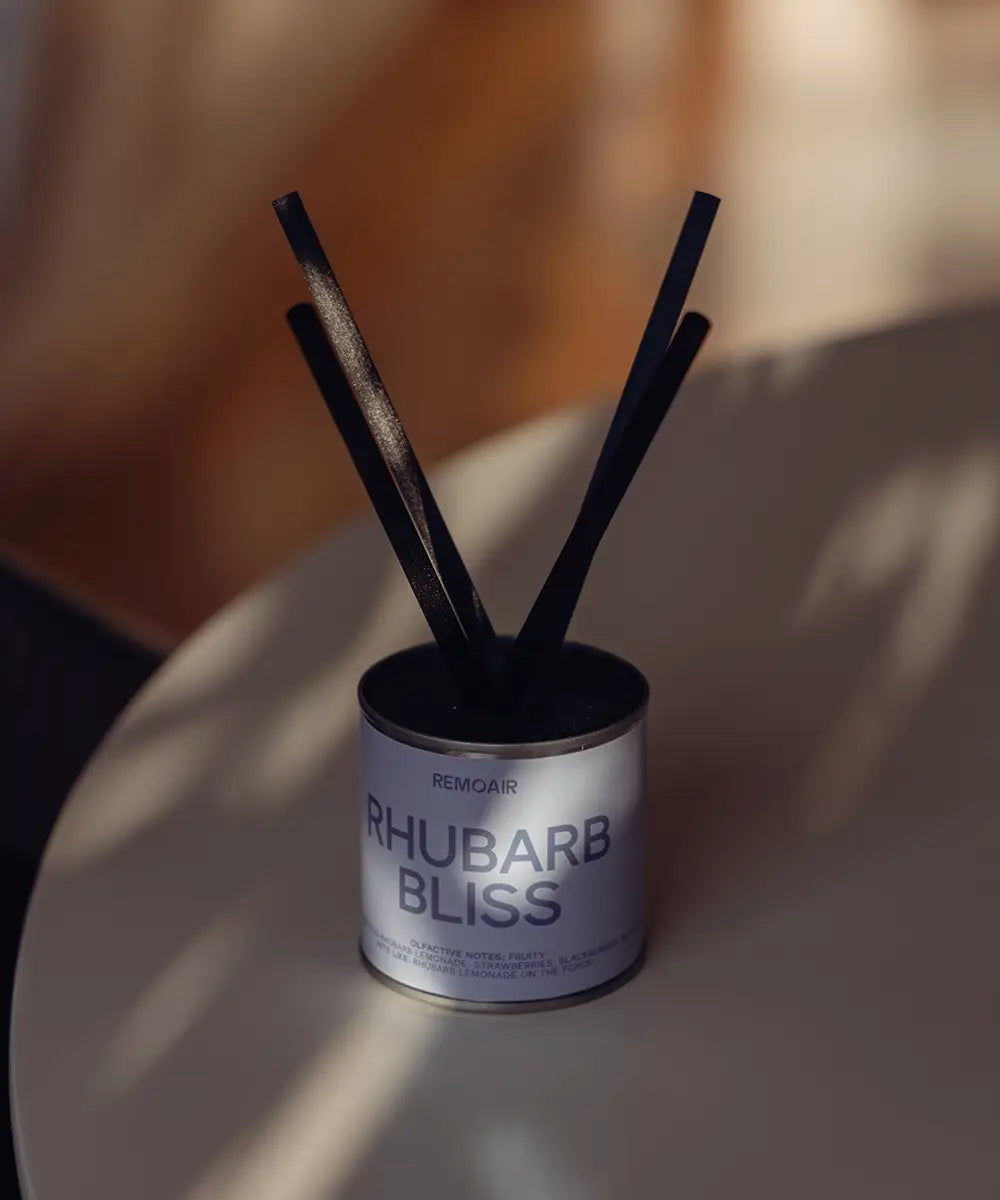 Rhubarb Bliss doftset med korta svarta stickor och stilren ljusblå detalj på ett bord.