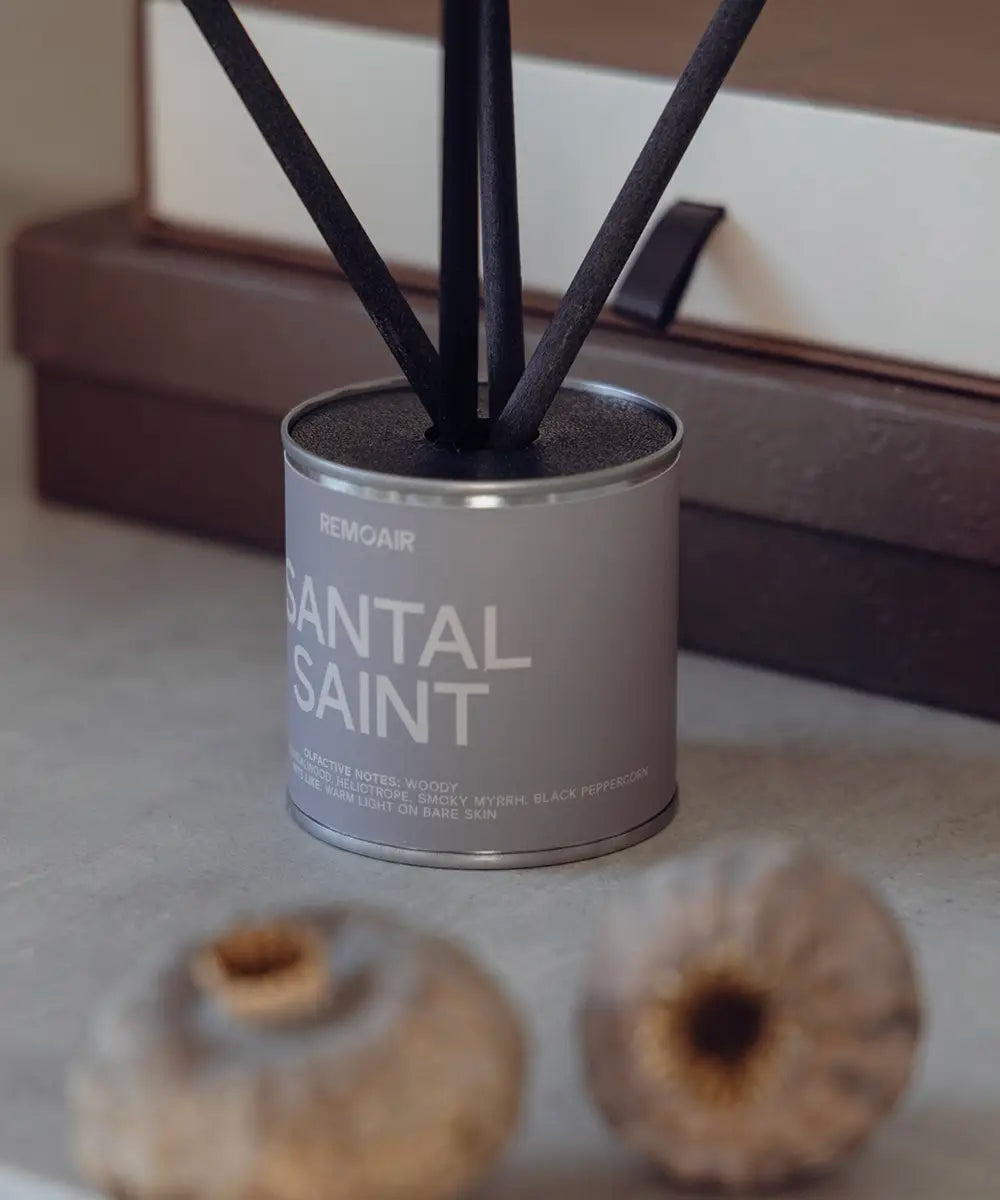 Närbild på Santal Saint doftpinnar med svart lock och korta lyxiga stickor i modern hemmiljö.