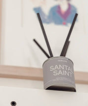 Santal Saint doftpinnar med sober gråbeige etikett i en harmonisk, skandinavisk miljö.